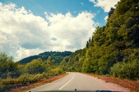 View of the mountain winding road through the windscreen in summer. Carpath.. Stock Photos