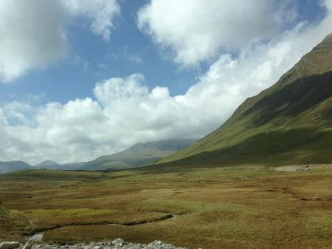 View of mountains and fields with endless fields and a river at the foot of the Stock Photos