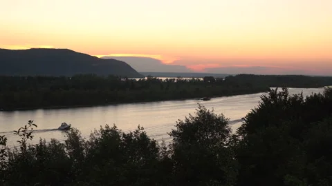 View of the mountains and the river at sunset. View from a hill. Boats float on Stock Footage 136440593