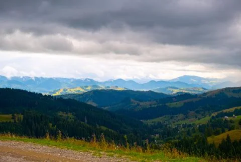 View of the mountains, a large gray cloud hangs in the sky, creating a shadow Foto stock