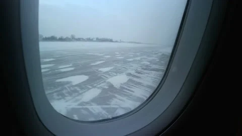 View from the moving airplane window on the takeoff-landing strip in the snowy Stock Footage 152604552