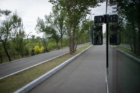 View from a Moving Bus Window Driving Along a Scenic Tree-Lined Road Stock Photos