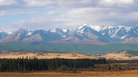 View From Moving Car Of Mountain Range With Snowy Peaks And Autumn Meadows Stockbeeldmateriaal 166027590