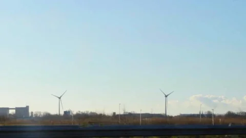 View from a moving car to rotating wind power plants Stock Footage 103733922