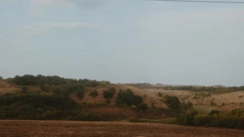 View from a moving train shows rolling hills with autumn foliage. A journey Stock Footage 323913904