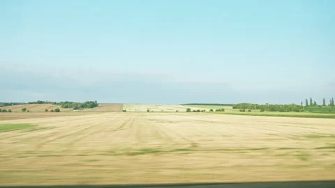 View from a moving train window looking at fields as another train passes by Stock Footage 342018961