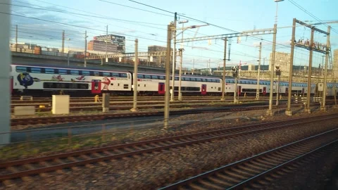 View from a moving train window of railway tracks and passing passenger cars Stock Footage 340755831
