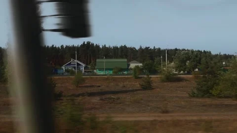 A view from a moving train window of a village, forest, and nature. Train travel Stock Footage 317812846