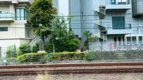 View from a moving train windows passing by urban buildings in Tokyo Japan. Stock-Footage 334578530