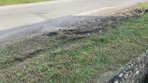 View of the muddy ground on the side of the road Stock Photos