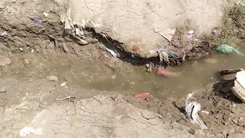 A view of muddy water flowing in a small ditch Stock Footage 253177447