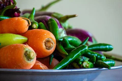 View of multi-colored vegetables (carrot, chili pepper, brinjal) in a bowl Stock Photos