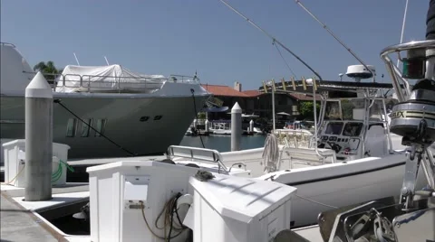 View of multiple yachts at dock sailboat bow in foreground back of fishing bo Stock Footage 67510212
