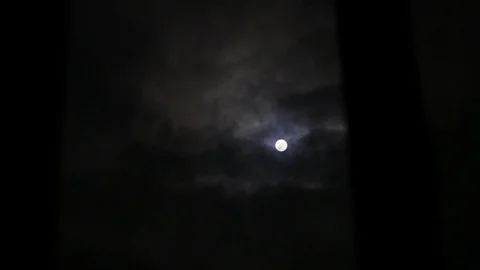 View on the mystical cloudy moon through the window. Stock Footage 129966058