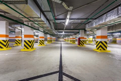 View of new empty underground parking with concrete columns and nobody inside Stock Photos