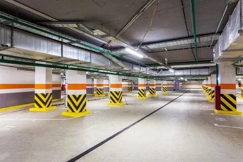 View of new empty underground parking with concrete columns and nobody inside Stock Photos