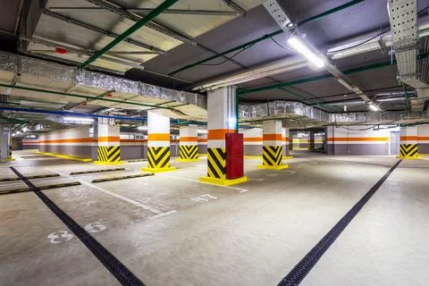View of new empty underground parking with concrete columns and nobody inside Stock Photos