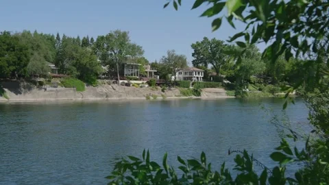 View of nice river homes in spring on the shoreline of a river Stock Footage 309144024