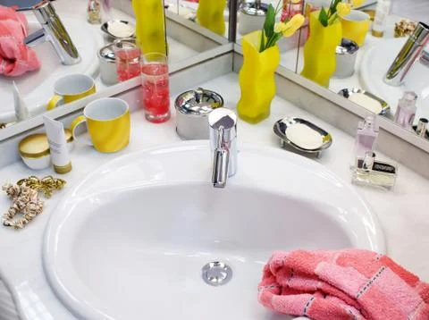 View of nice silver sink and faucet with yellow tulips in a yellow vase, pink Stock Photos