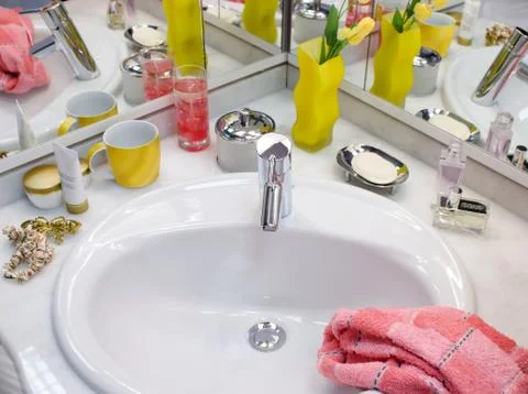 View of nice silver sink and faucet with yellow tulips in a yellow vase, pink Stock Photos