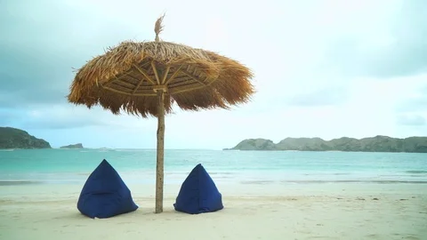 View of nice tropical empty sandy beach with umbrella and beach chair Stock Footage 128410150