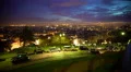View of night city from the mountain top, cars driving along illuminated street 4k or 4k+ Resolution