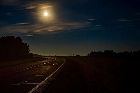 A view of a nighttime, romantic, paved, empty road Stock Photos