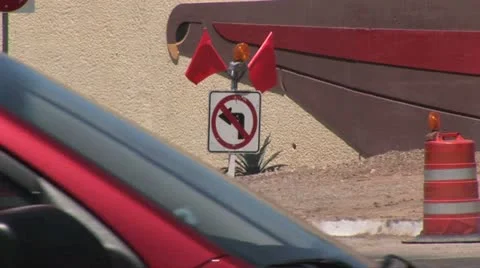 View of "No Left Turn" Traffic Control Sign and Safety Barrels As Traffic Passes Video stock 19133069