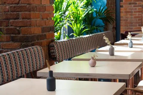 View of a number of empty tables in a cafe on a background of a brick wall an Stock Photos