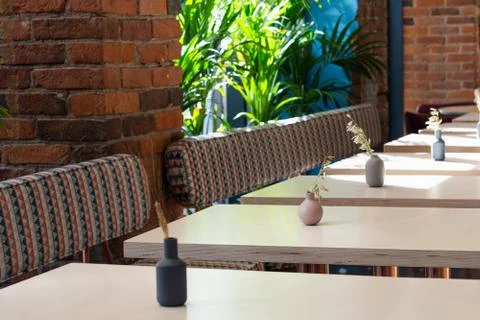 View of a number of empty tables in a cafe on a background of a brick wall an Stock Photos
