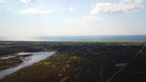 View of the ocean and landscape from above near coastline in a sunny sky wi.. Stock Footage 339934001
