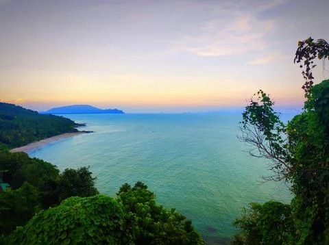 View of ocean and trees during sunset near a beach in a coastal area. Khano.. Stock Photos