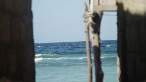 View of the ocean between small brick homes in Bali Indonesia Stock Footage 145031503