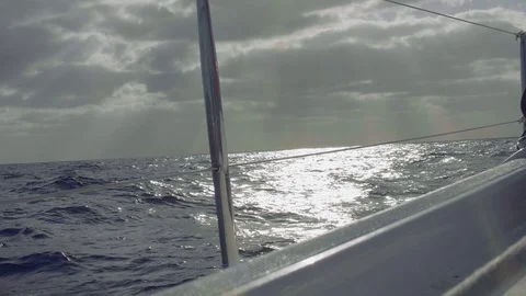 View of ocean from left board of sailing yacht. Sun rays creeping through clouds 스톡 동영상 87890597
