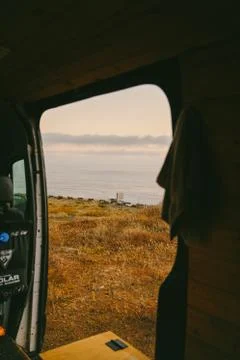 View of ocean over cliffs from door of sprinter van in Baja, Mexico. Stock Photos