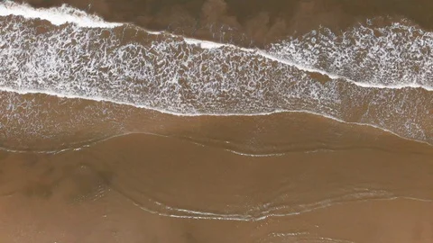 View of ocean waves crashing on beach with people walking by on beautiful beach. Video stock 102426169