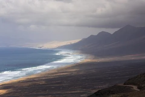 View of ocean waves rolling on the shoreline at Playa de Cofete along the Mou Foto stock