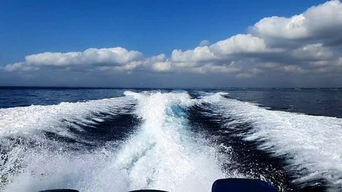 View of ocean waves in slow motion from the back of a fast boat while going t Stock Footage 129881950