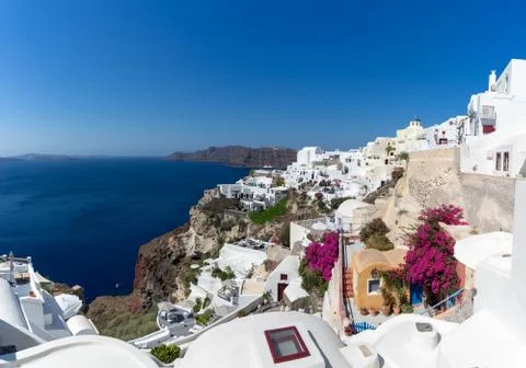 View of Oia town in Santorini with old white houses and windmill Stock Photos