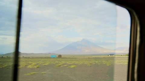 View of Ol Doinyo Lengai volcano in Tanaznia during drive from safari car window Video stock 307717994