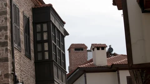 View of old brick house with beautiful new black shutters against sky and roofs Stock Footage 235228957