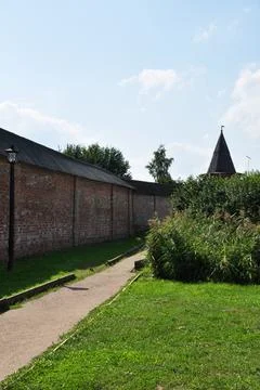 View of the old brick wall and the conical roof of the tower. Stock Photos