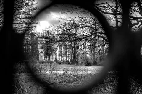 View of an old building in a park through a circular ornament of a metal fenc Fotos de archivo