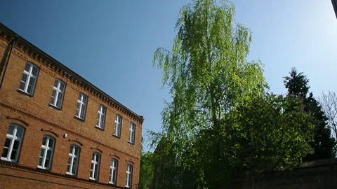 View of old castle through green trees and red brick building Stock-Footage 107239533