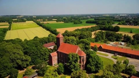 View of an old church surrounded by fields and trees in Germany Stock Footage 339782667