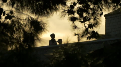 View of an old couple walking at sunset seen through trees in Dubrovnik, Croatia Video stock 59006402