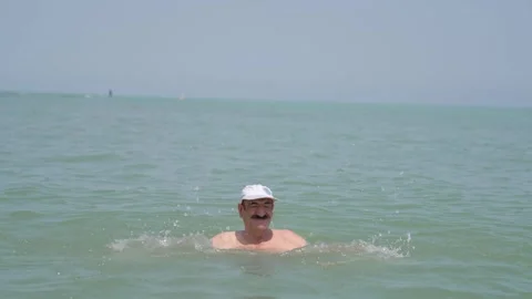 A view of an old man playing in the sea Видео 246759760