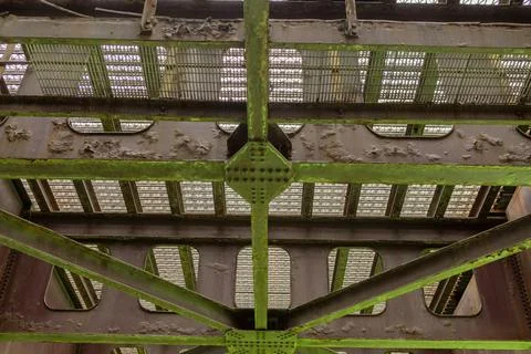 View of an old metal bridge structure with rust and green patches under bri.. Stock Photos