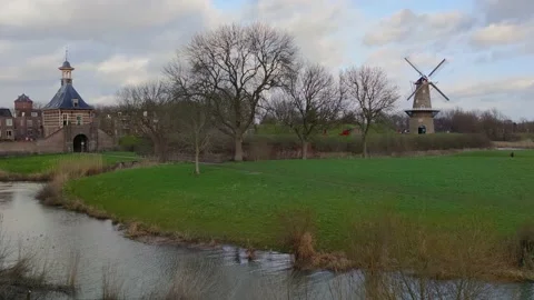 View of old rotating windmill and historical city gate in dutch city Gorinchem Stock Footage 169960109