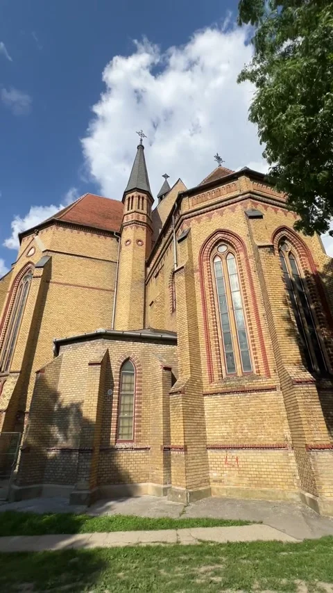 A view of an old tall brick building with turrets and religious paraphernalia Stock Footage 279460917